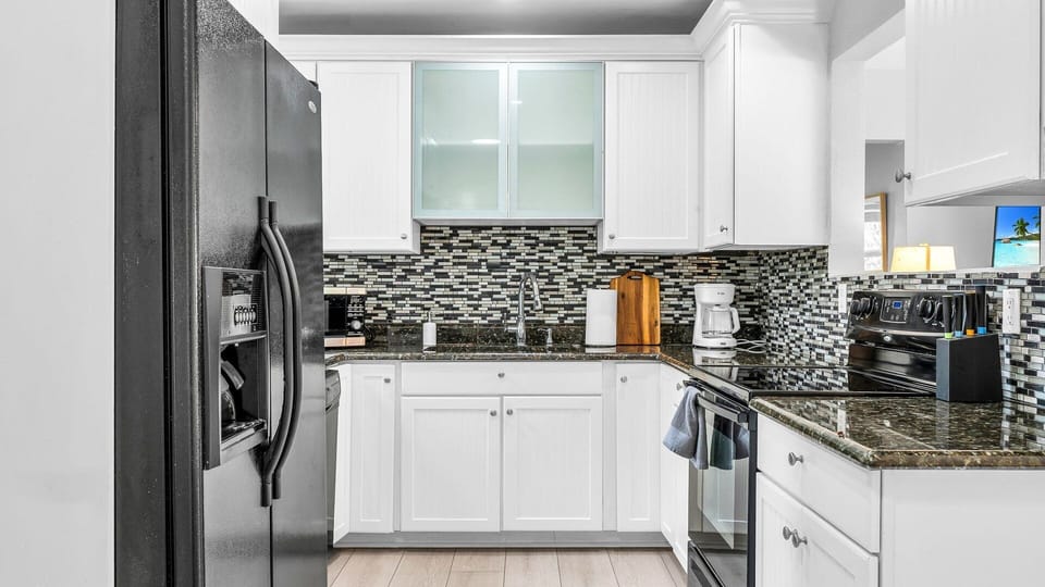 Fully equipped kitchen with granite countertops, a blender, filter coffee machine, and indoor/outdoor tableware for 6. Enjoy easy access to the dining room for effortless entertaining.