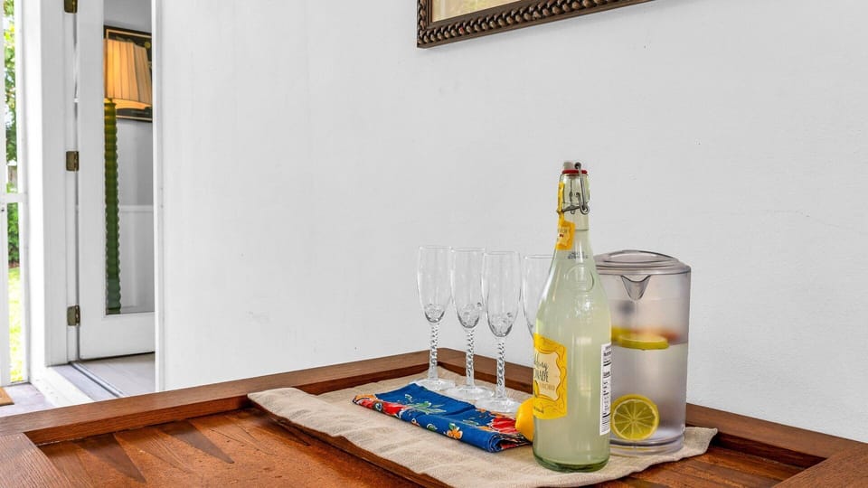 Relax and dine al fresco in the spacious screened-in porch, complete with comfortable lounge seating, a ceiling fan, and outdoor dining for six—all surrounded by lush tropical greenery.