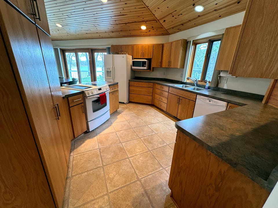 Kitchen fully equipped for preparing, serving and consuming meals. 