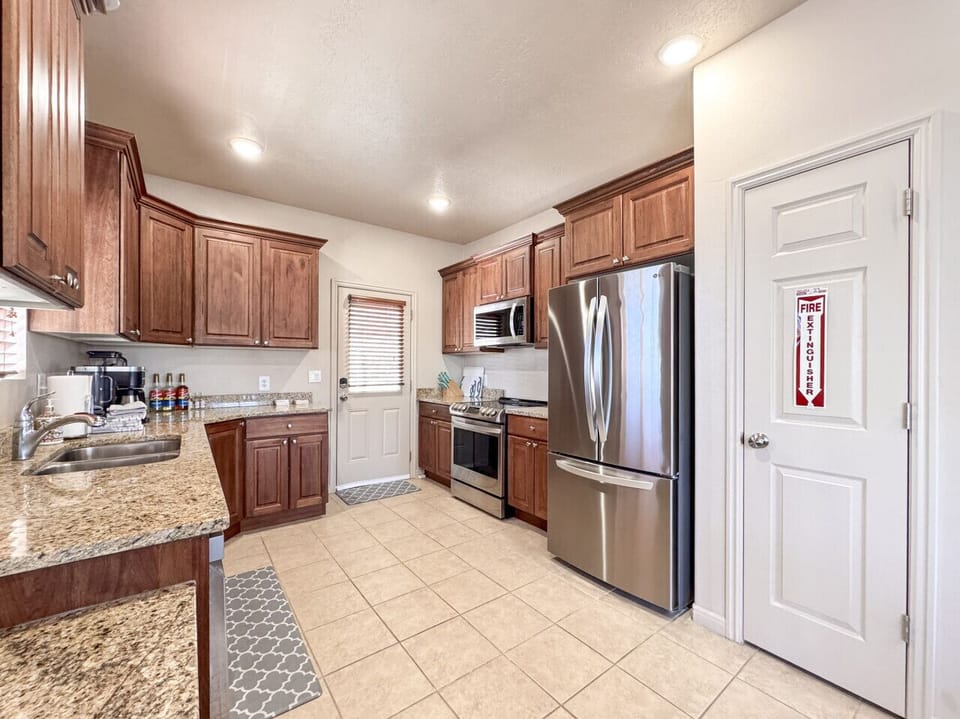 Modern kitchen with stainless steel appliances and warm wood cabinetry—perfect for gathering and cooking together.