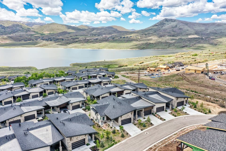 Aerial view showcasing lakeside community and stunning mountain backdrop.