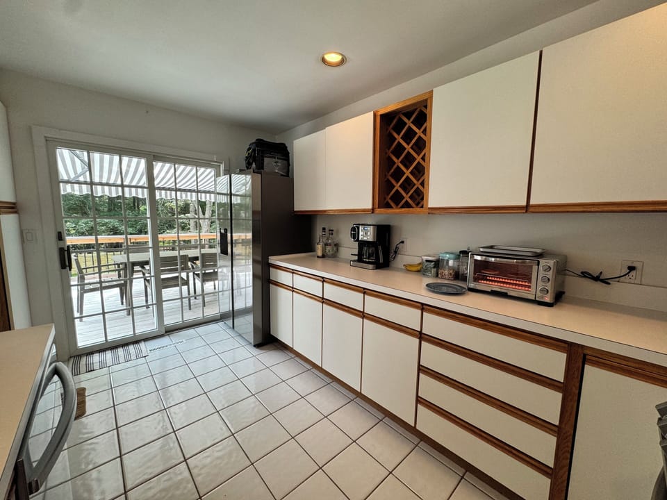 Fully equipped kitchen with new appliances and sink, sliders right out to deck