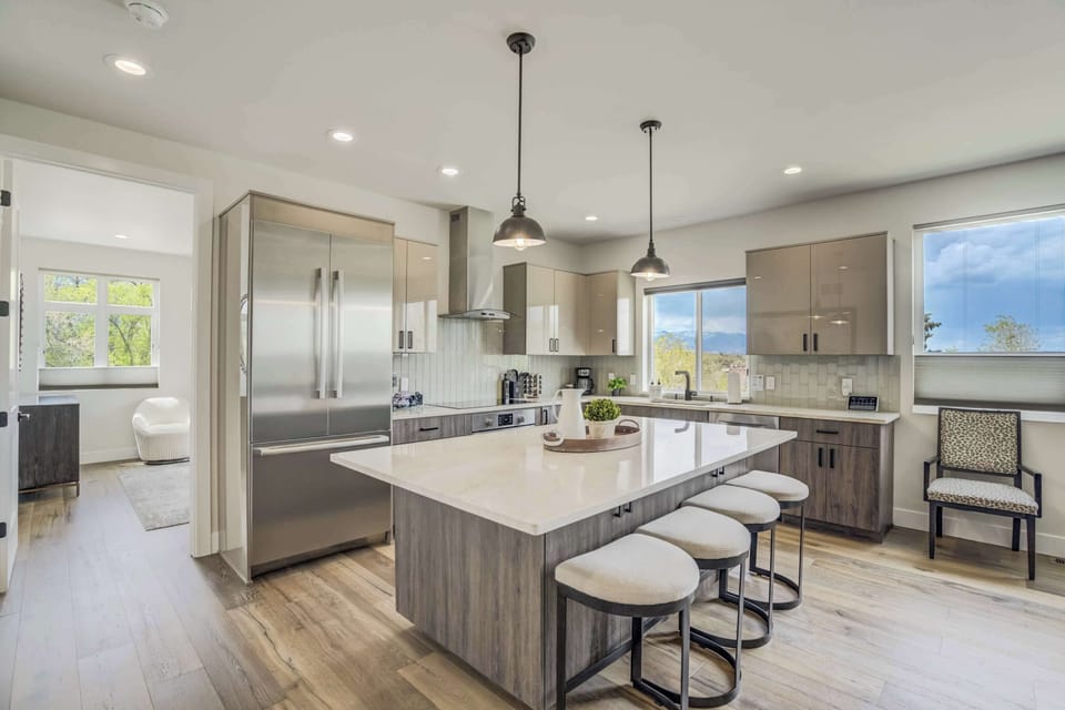 Modern kitchen with stainless steel appliances, quartz countertops, and a spacious island with seating for four. Perfect for meal prep, morning coffee, and gathering with loved ones..
