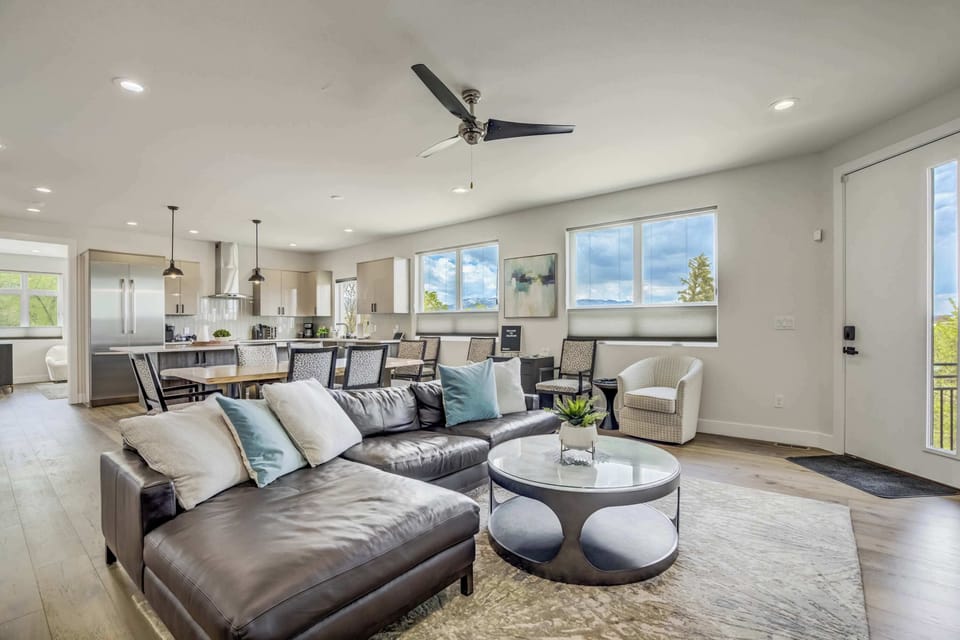 Open-concept living area filled with natural light, featuring a cozy sectional, elegant decor, and seamless flow into the kitchen and dining space. Perfect for entertaining and family gatherings.

