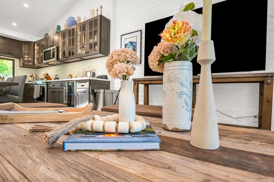 Details matter. A touch of floral, a flicker of candlelight, and a cozy coffee table moment that brings the whole room together.