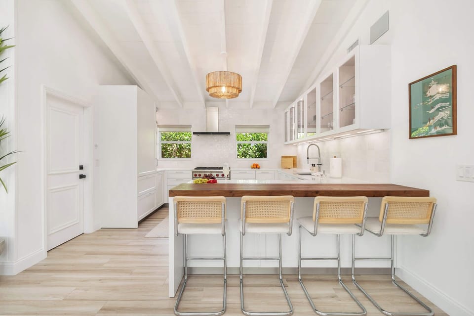 Modern kitchen with a wooden breakfast bar and natural light from two windows