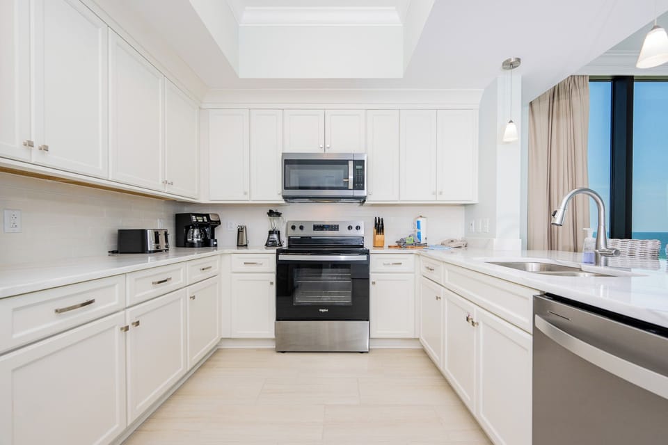 Prepare meals in this kitchen featuring stainless appliances and a beachfront view