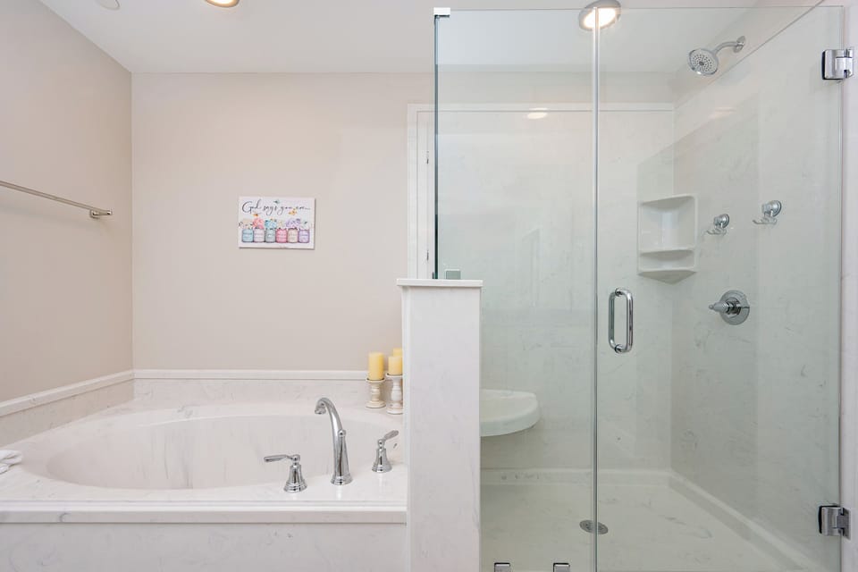Indulge in relaxation with a soaking tub and walk-in shower, complemented by soft lighting and decorative accents