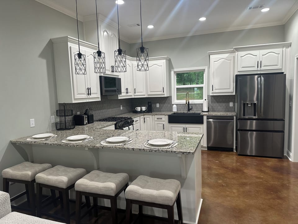 Kitchen includes gas stove, oven, microwave, and other kitchen tools. 