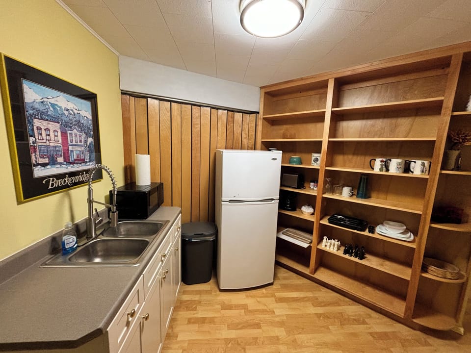 Kitchenette with microwave, coffee pot, refrigerator and sink.
