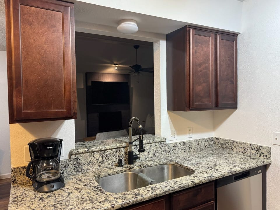 Kitchen sink, dishwasher and coffee maker.