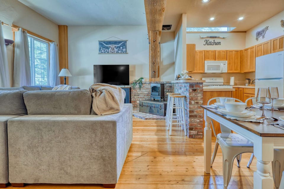 Thoughtfully placed décor, including wooden accents, ranch-themed artwork, and soft throw blankets, contribute to the warm, inviting feel of the living room. CB1