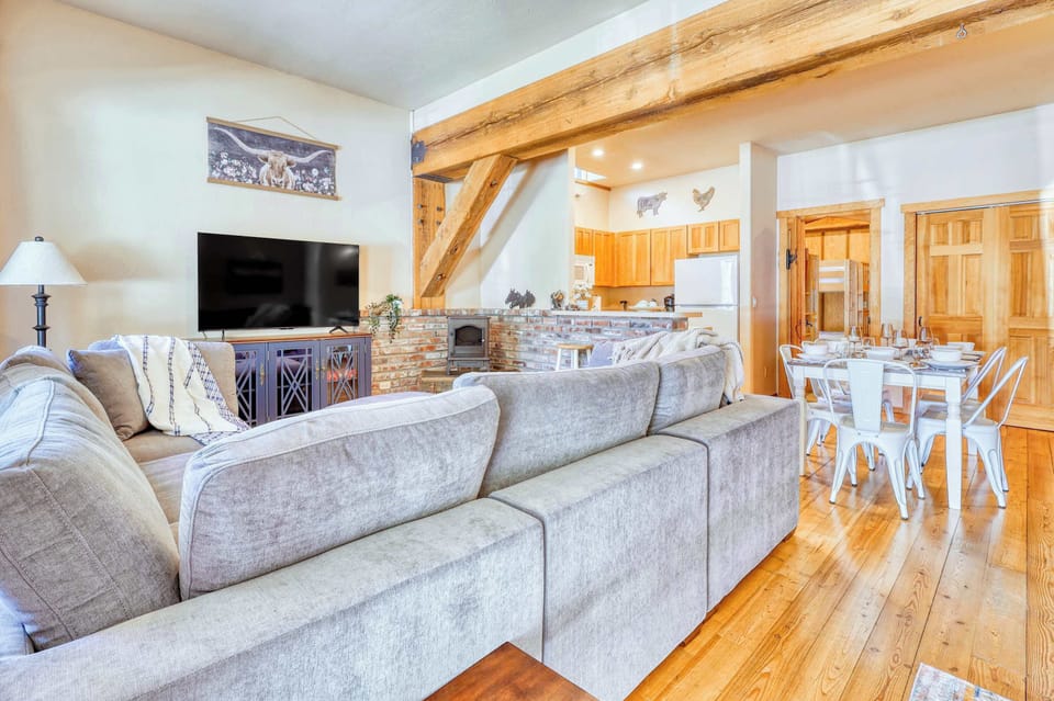 Large windows in the living area allow natural light to flood the room, offering beautiful views of the surrounding forest while maintaining a warm, cozy atmosphere.