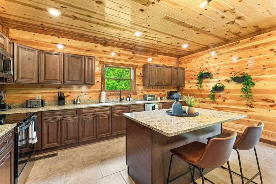 Fully equipped chef’s kitchen with granite countertops and bar seating.