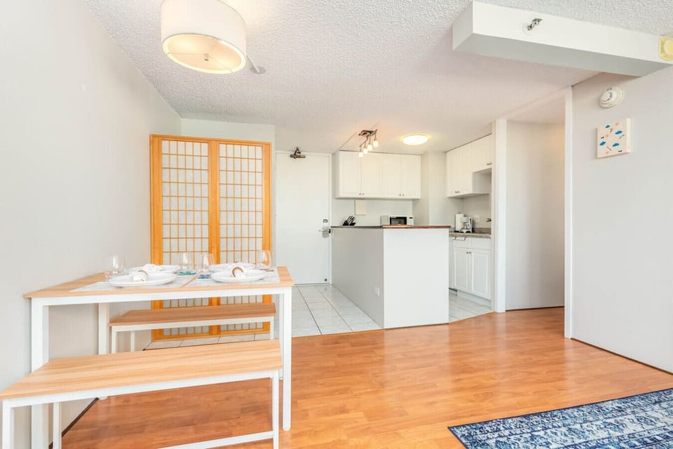 This kitchen is sleek and modern, with white cabinetry, stainless steel appliances, and a small island under warm lighting, your family’s favorite moments start right here