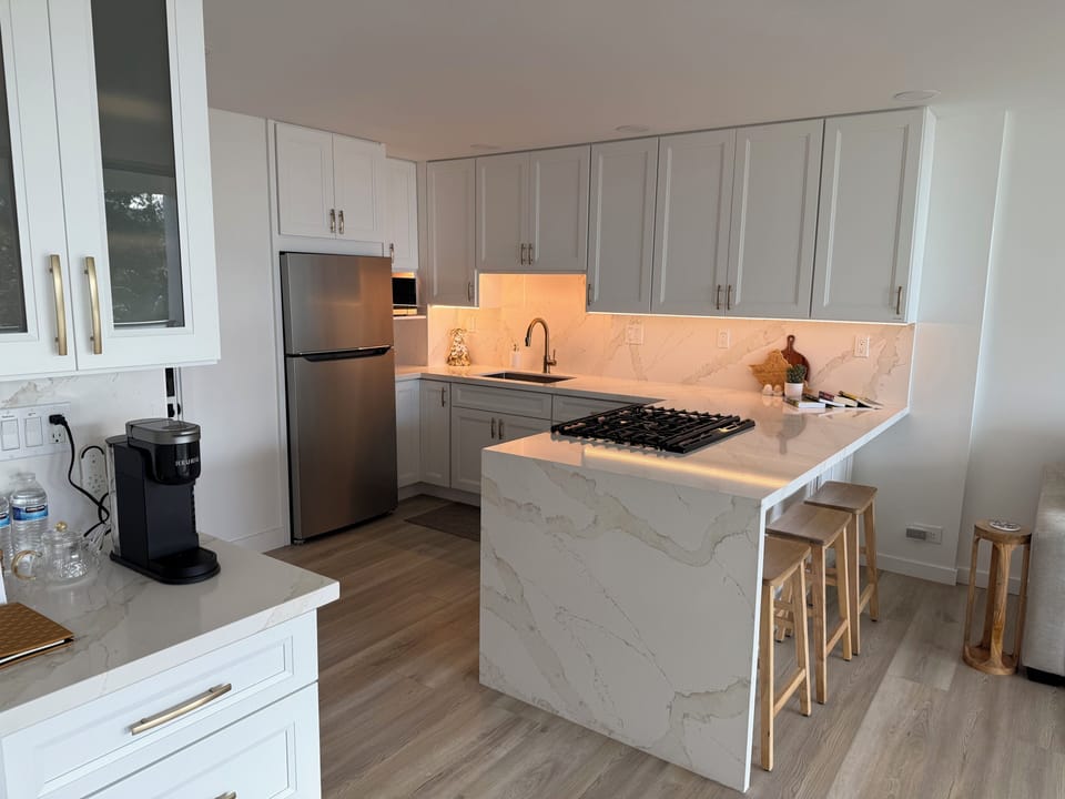 Fully stocked kitchen with under cabinet lighting, microwave, ice maker.