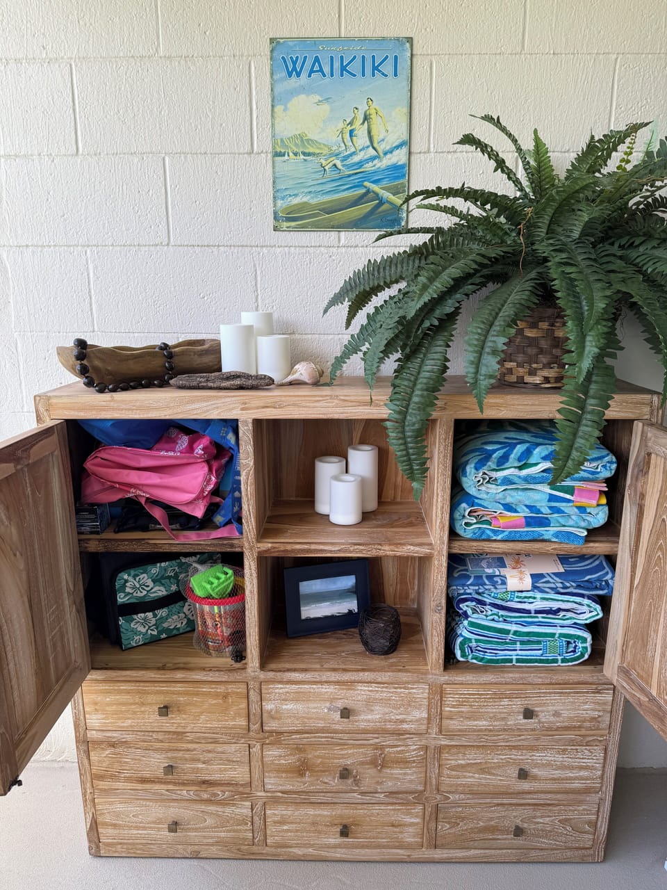 Bali teak cabinet stocked with beach essentials. Flameless candles with remotes.