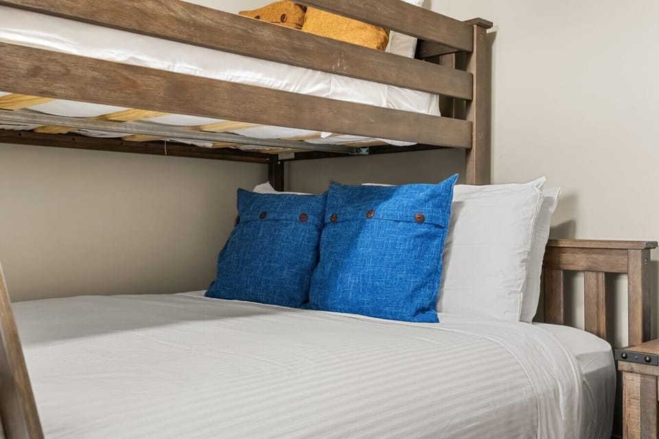 Second bedroom with a single-over-queen bunk bed, closet, and room-darkening blinds.