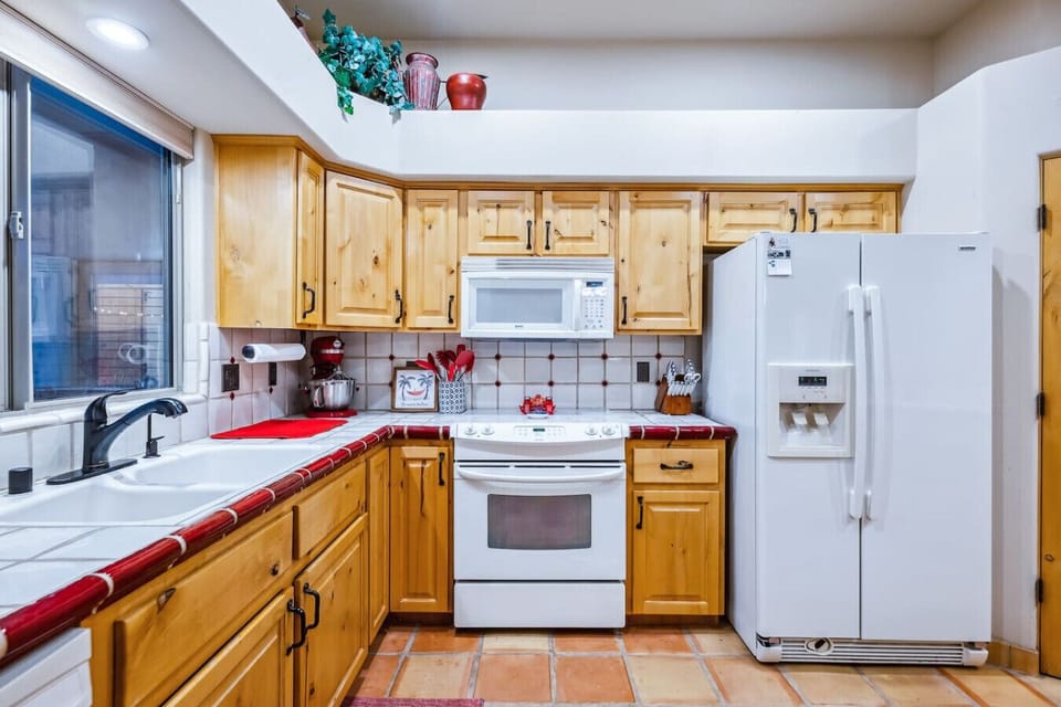Charming kitchen with Mexican tile accents, modern appliances, and abundant cabinet space.