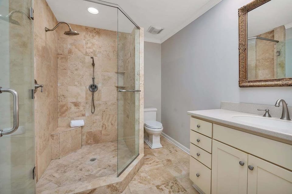 Bathroom with large tiled walk-in shower and vanity