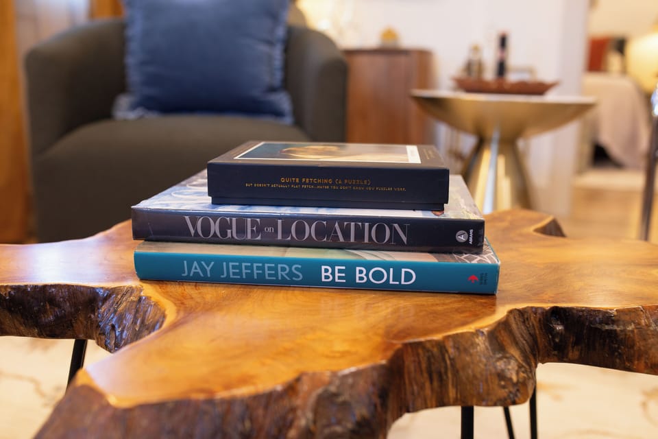 A curated selection of books resting on a striking wooden table.