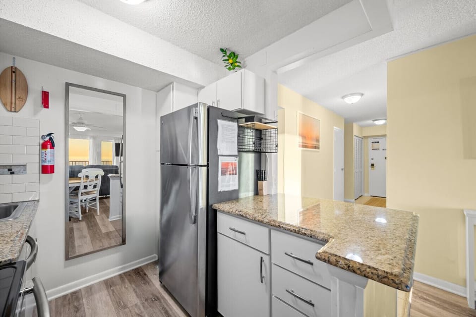 Bright, updated kitchen with granite countertops and easy flow from entry to living space for a seamless stay.
