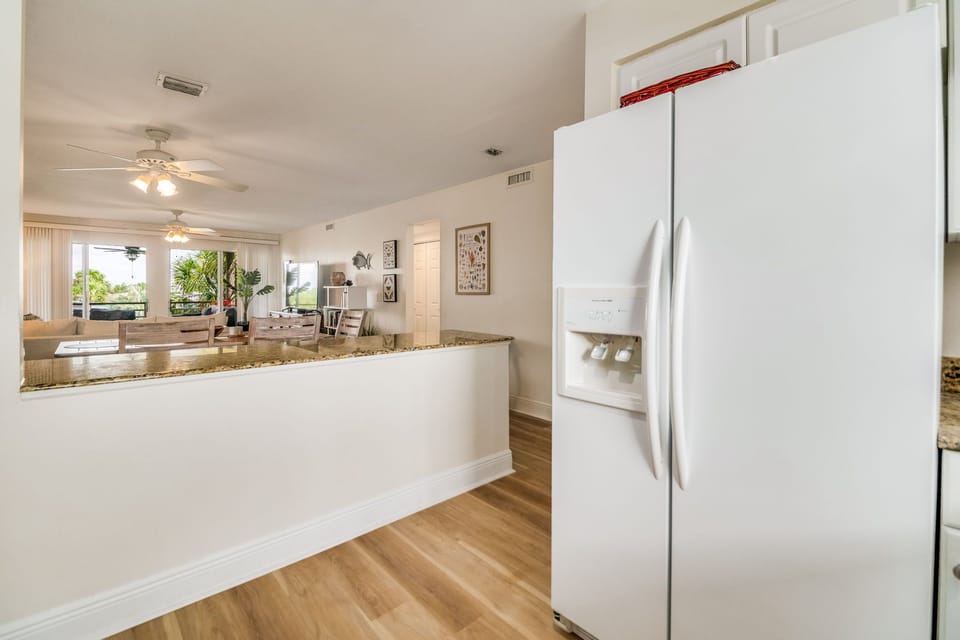 Updated white kitchen with granite counters and breakfast bar - fully equipped for vacation cooking