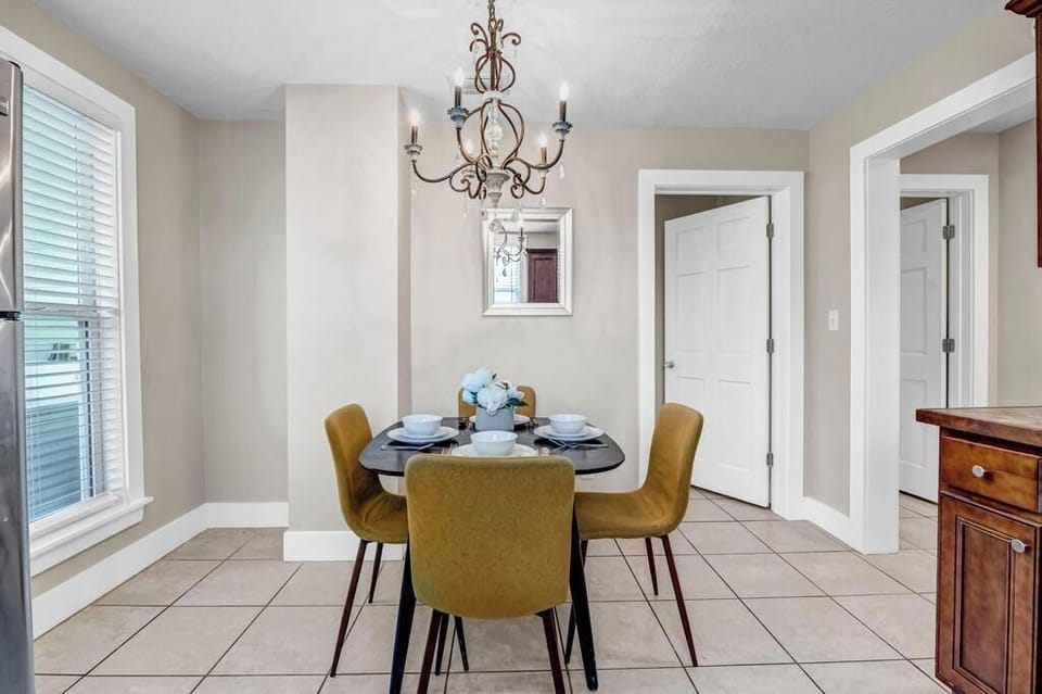 - Charming dining nook for four with sleek mustard chairs, chandelier lighting, & tiled floor
- Windows bring in natural light, creating the perfect setting for relaxed meals
- Enjoy brunch, board games, or wine nights in this cozy & stylish dining corner