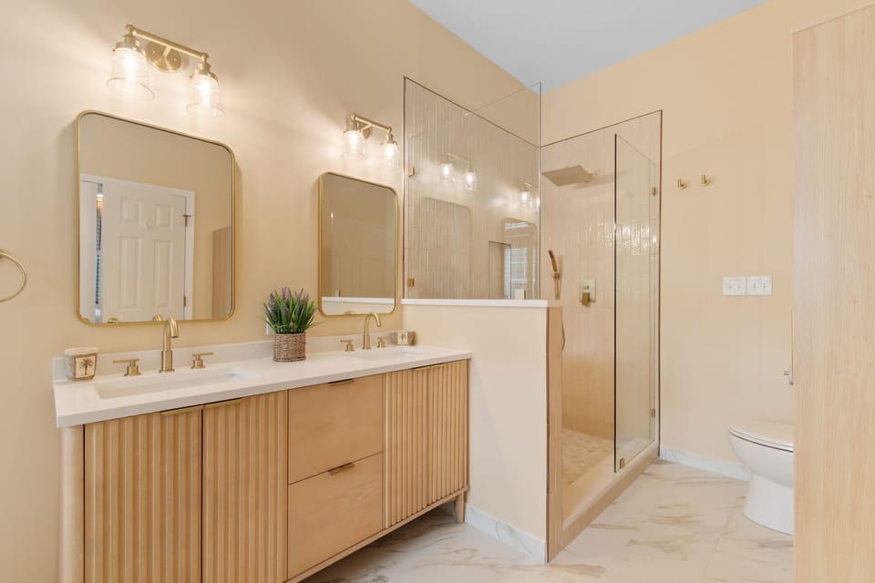 Unwind in your serene spa-like bathroom with dual vanities, rainfall shower, and warm wood finishes creating the perfect retreat.