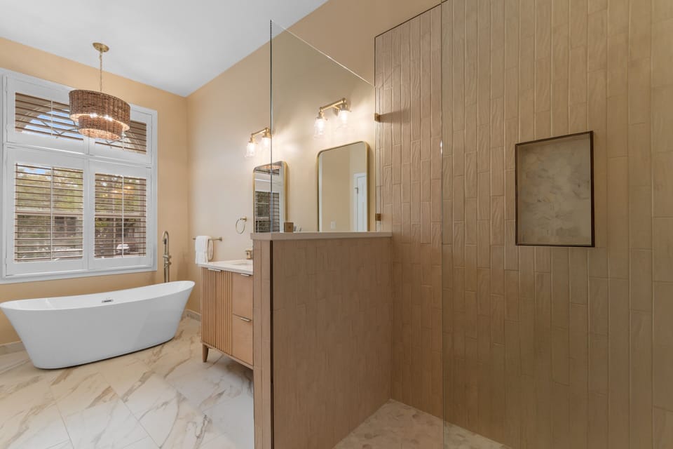 Unwind in your luxurious spa-like bathroom, where warm wood tones meet elegant floors and a dreamy soaking tub awaits.