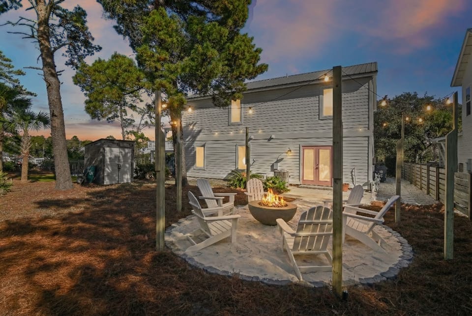 Private backyard fire pit with café-style string lights