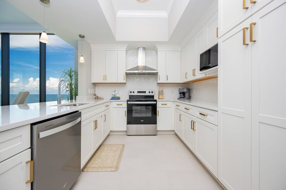 Prepare meals in this stylish kitchen featuring sleek cabinetry, stainless appliances, and a coffee corner
