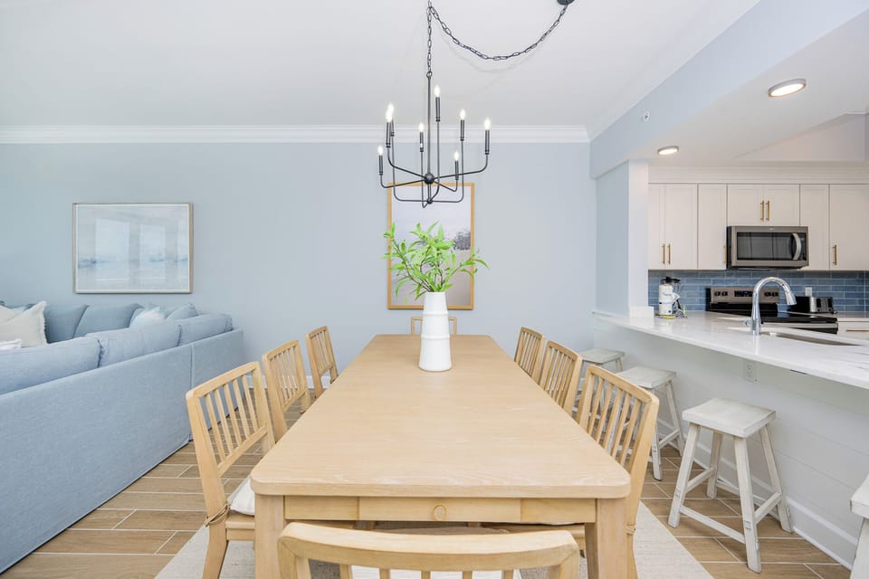 Dine at the spacious wooden table, surrounded by calming decor and a cozy vibe for memorable meals