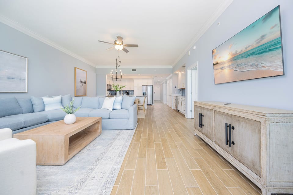 Relax in the spacious living area, featuring a large sectional sofa and a flat-screen TV