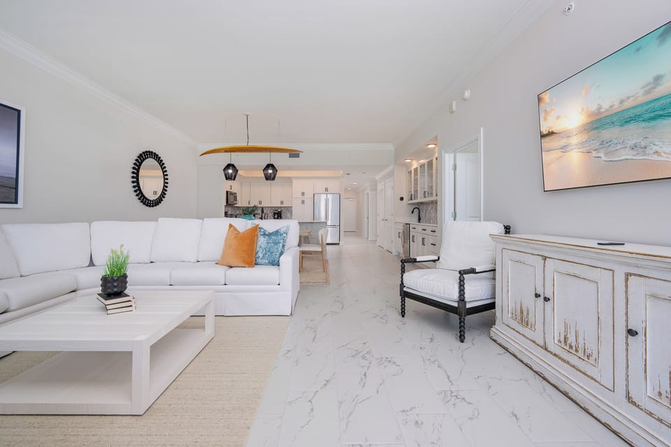 Relax in the spacious living area, featuring a plush sectional, stylish decor, and a large TV