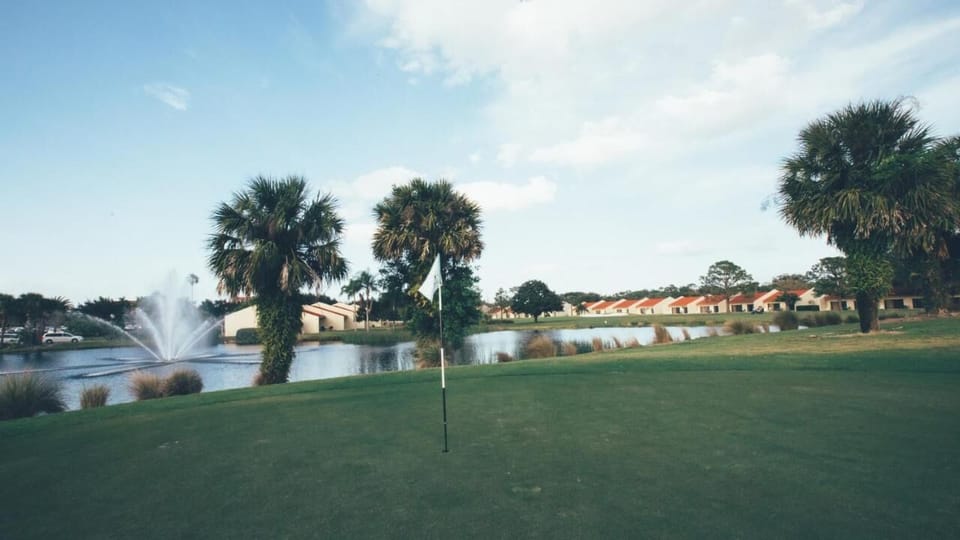 Practice your putt beside tranquil water views and palms