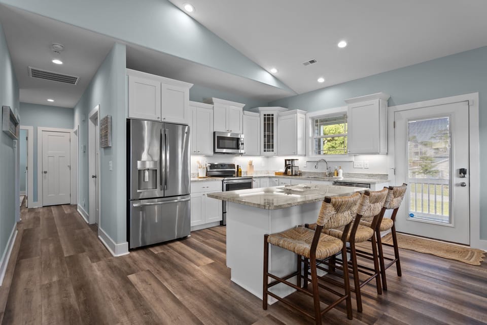 Easily transition from the kitchen to the screened outdoor dining area through the door pictured.