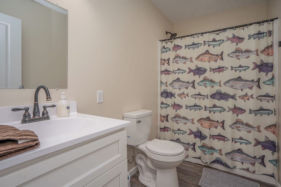 Simple, clean full bathroom with fresh touches and an easy shower/tub combo.