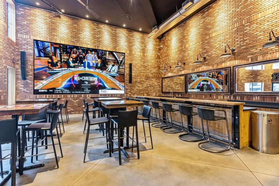 Bar seating w/ multiple TVs & vibrant setup for watching sports or socializing