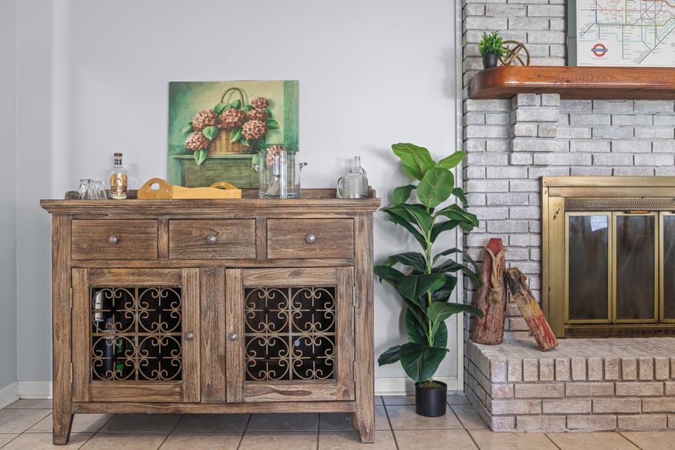 Cozy corner with rustic charm—featuring a vintage-style bar cabinet, fireplace, and thoughtful décor touches. Perfect for winding down with a drink or enjoying quiet moments by the fire in a space that feels both warm and welcoming.