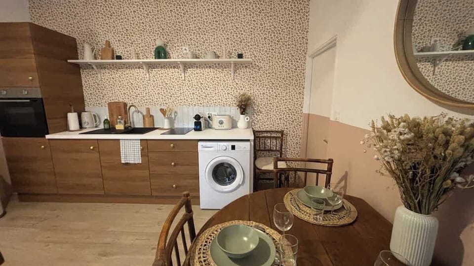 Cuisine ouverte sur le salon, équipée avec four, plaques de cuisson, machine à laver, lave vaisselle, bouilloire, grille-pain, machine à café, micro-ondes et petit réfrigérateur.