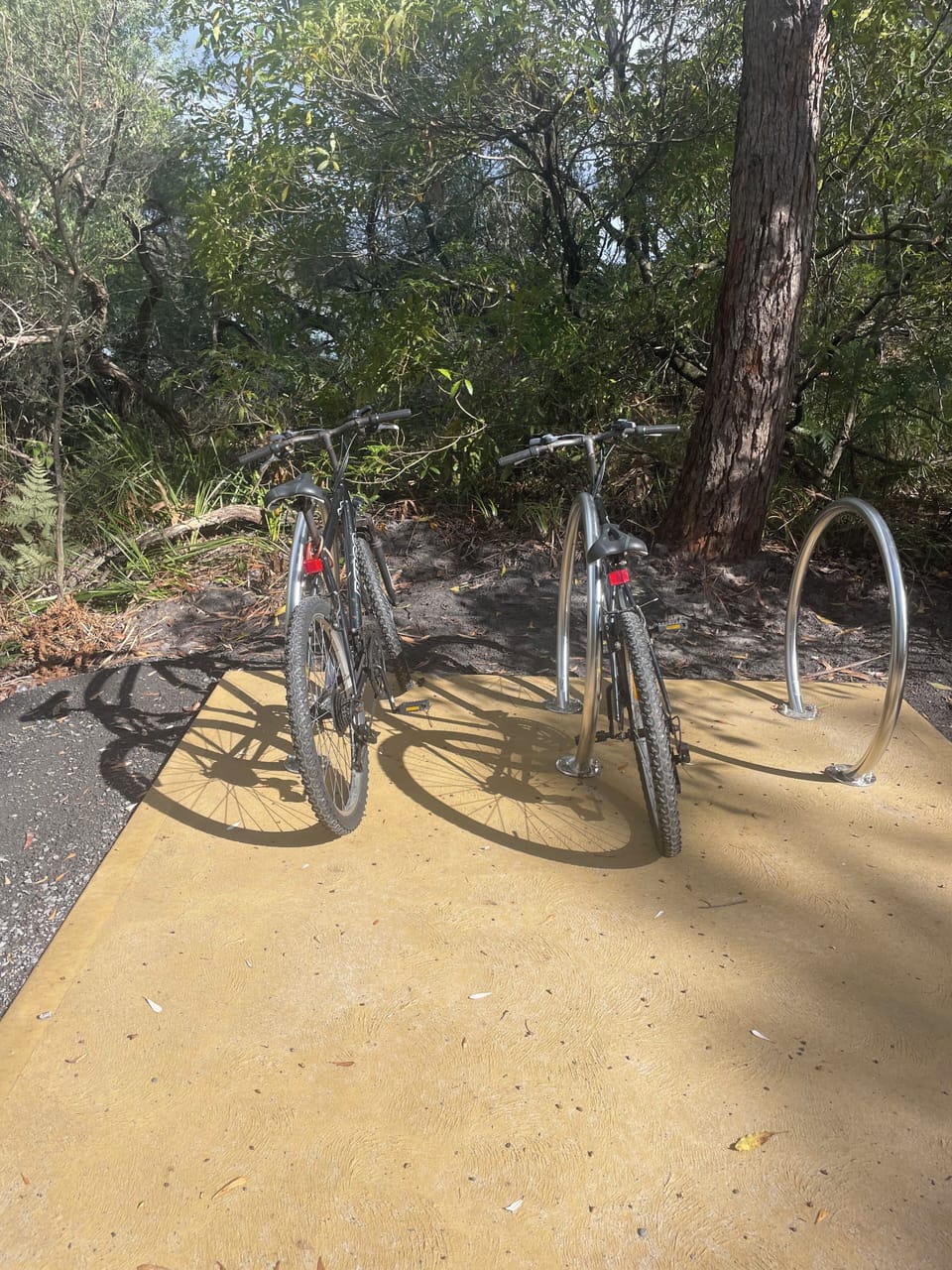 Bicycles parking rack in Myola with access to the creek's beach