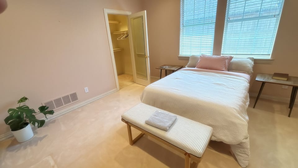 Bedroom 2 with excess pillows, plants, and adjacent to bathroom