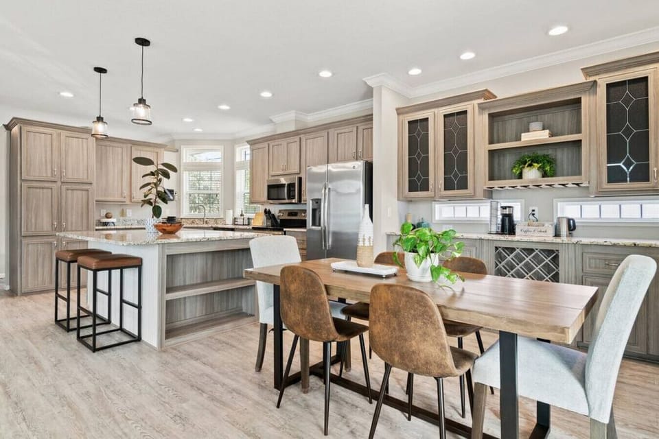 Modern kitchen and dining area offer a spacious layout with a large island, perfect for preparing and enjoying meals together in your tropical setting.
