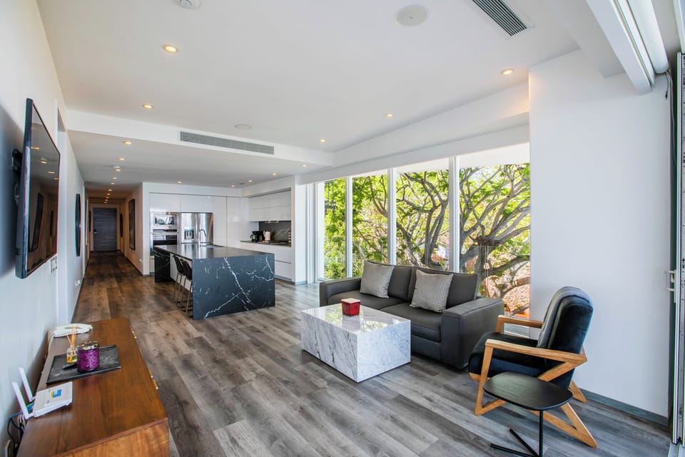 Living Room — Spacious area with a comfortable sofa, smart TV, and direct access to the balcony