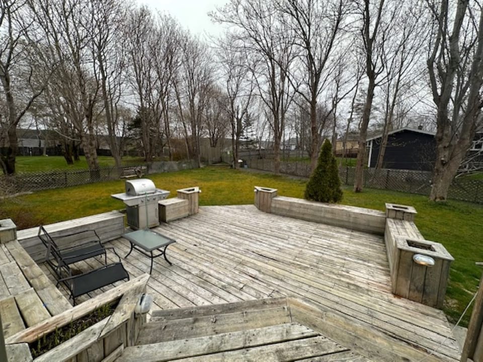 Rustic wooden deck with built-in seating and BBQ—ideal for outdoor gatherings.