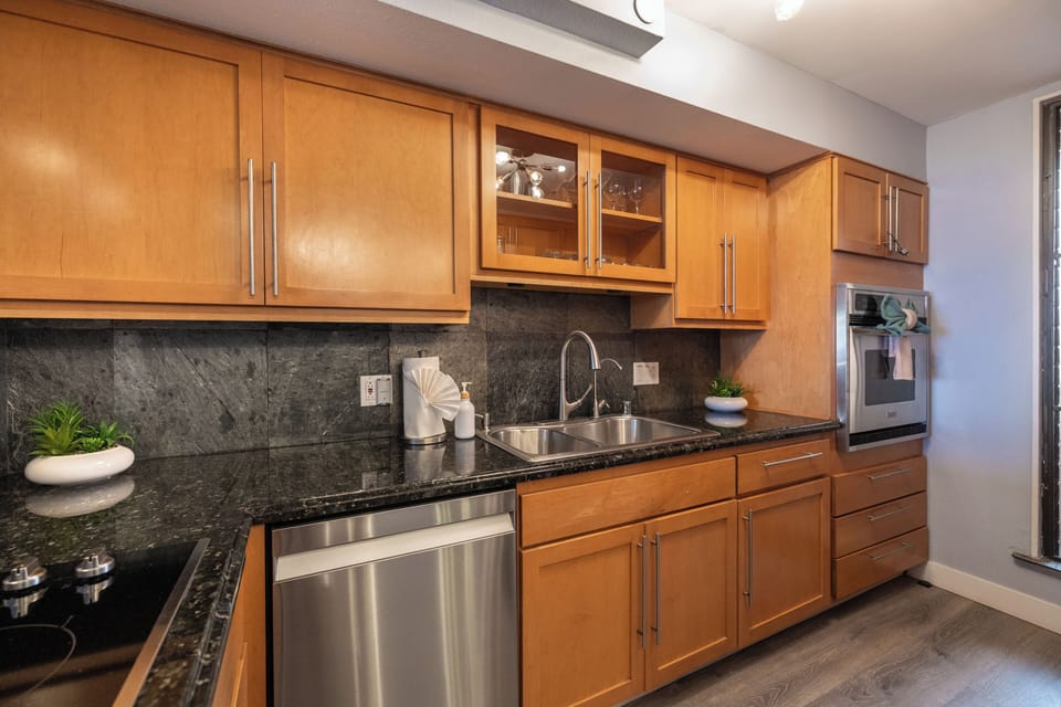 This vacation rental features an elegant kitchen with rich cabinetry, upper glass display doors, and all the essentials for a comfortable, home-style island retreat.