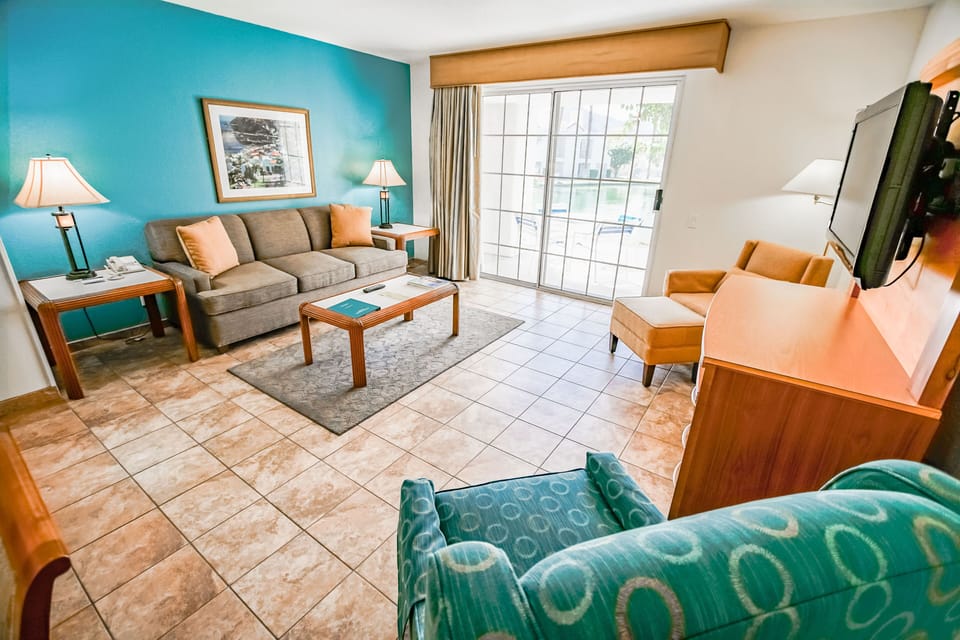 The inviting living space features a cozy sofa, modern decor, and a private patio access, making it a comfortable retreat after a day of adventure.