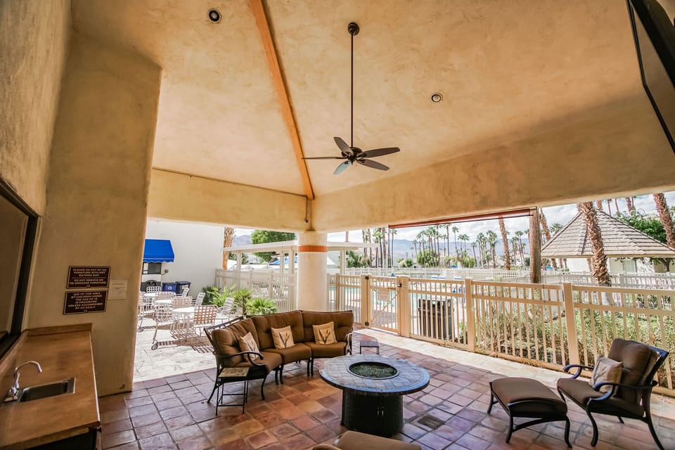Outdoor fire pit area with lush palms and nearby pool views—perfect for evening lounging.