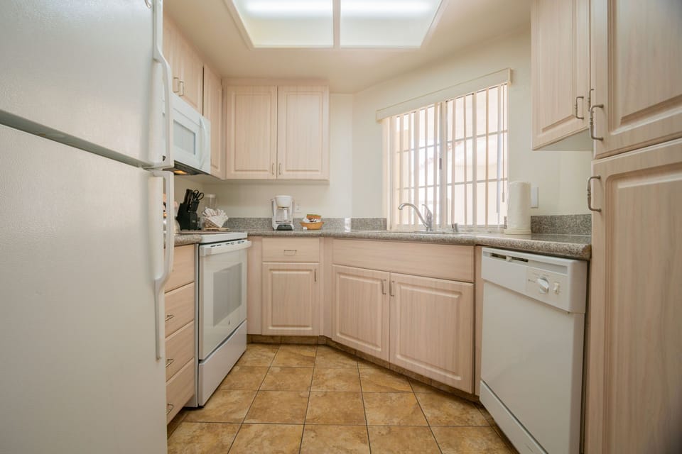 The full kitchen, complete with modern appliances and ample counter space, invites culinary adventures and family meals in a cozy setting.